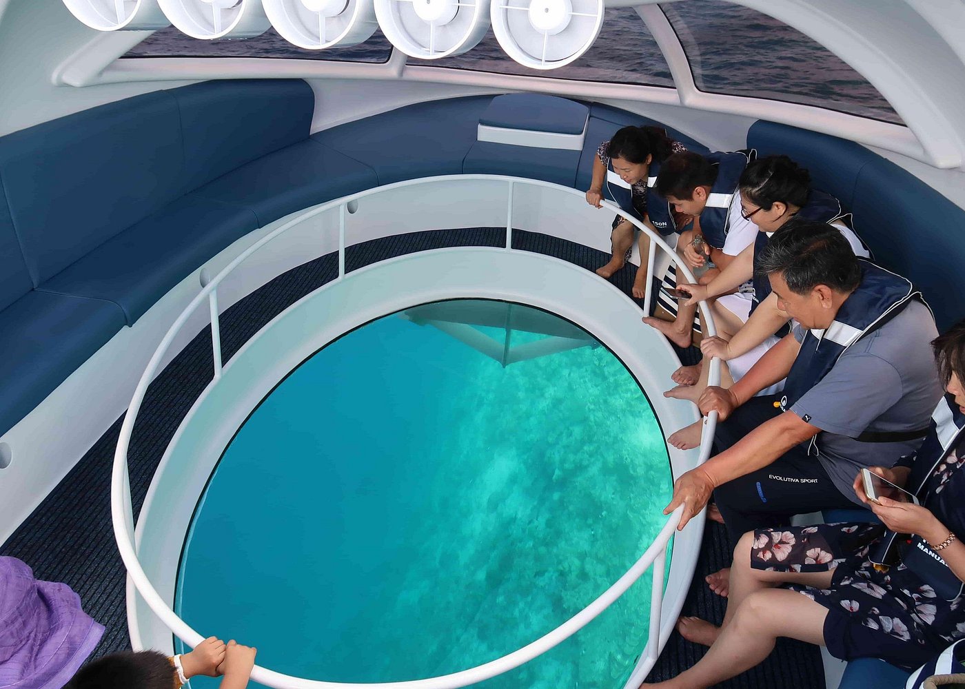 Kids looking through glass bottom boat at reef below — family activity Curaçao
